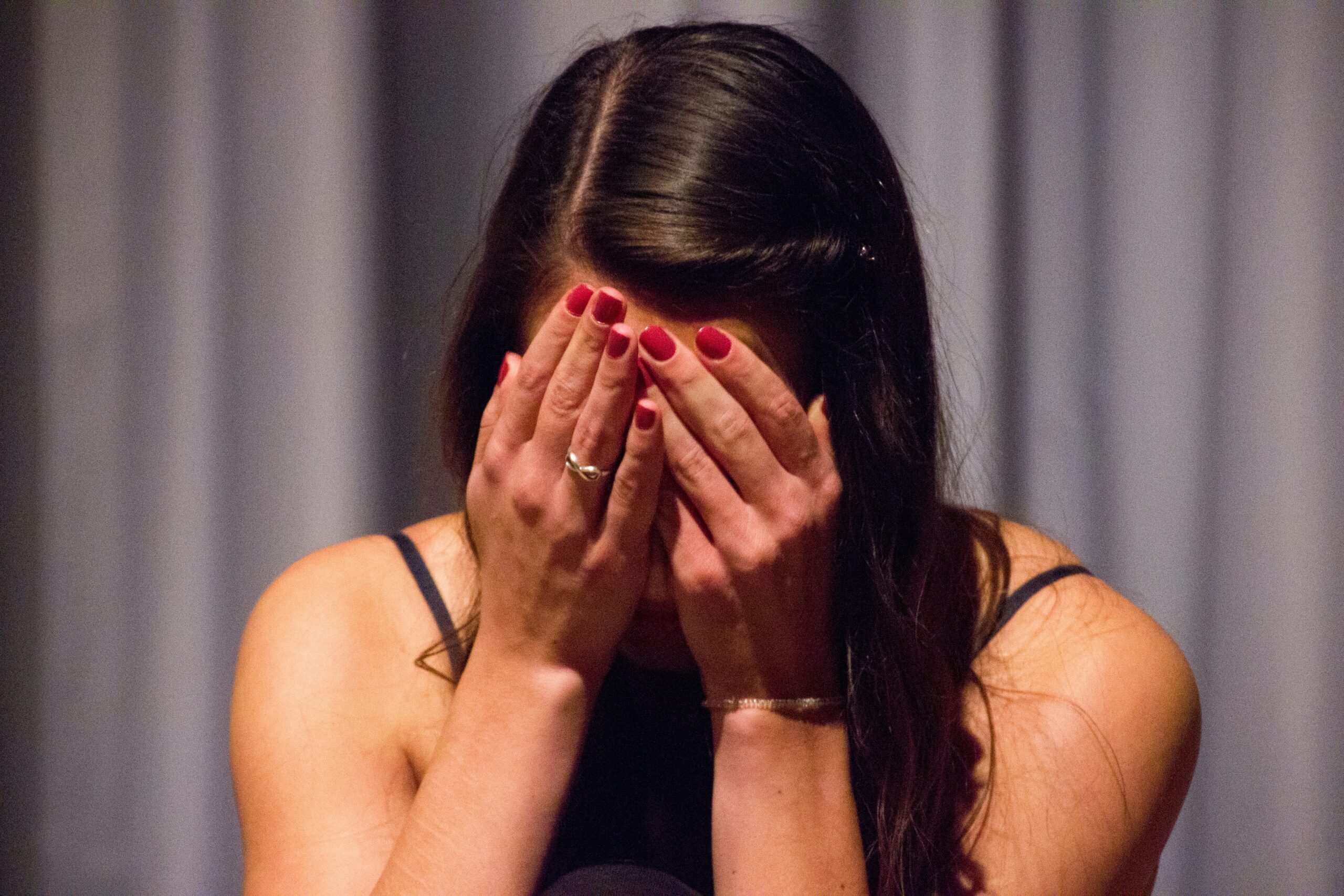 A woman with her face in her hands | Source: Unsplash
