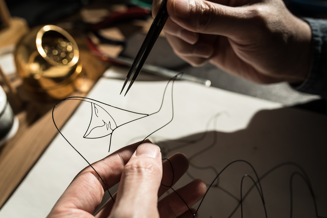 A person crafting a wire sculpture of a woman | Source: Pixabay