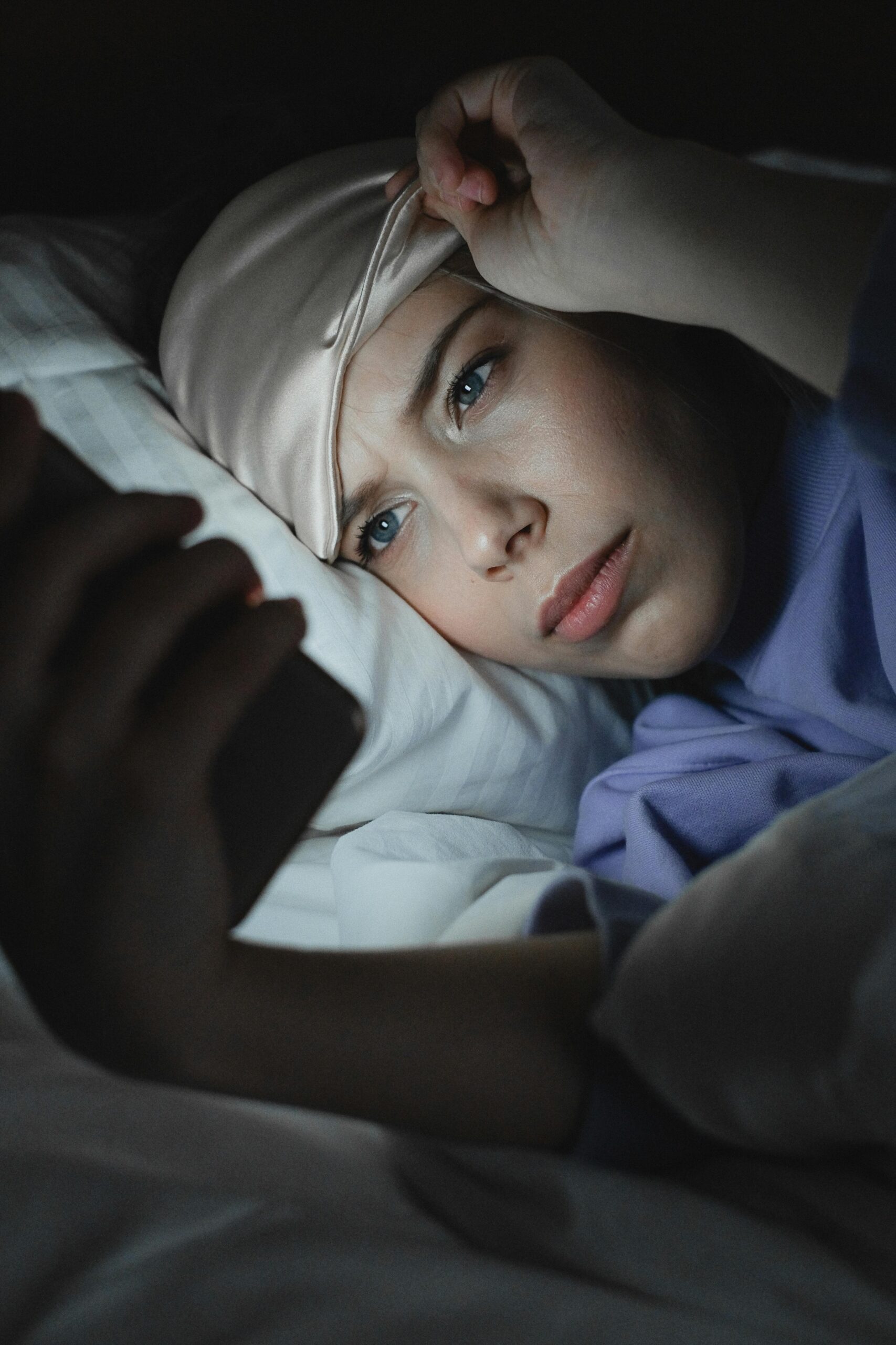 Woman uses cellphone at night | Source: Pexels