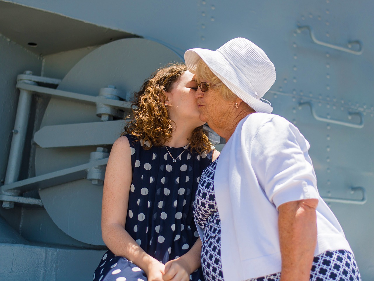 A younger woman kissing an older one