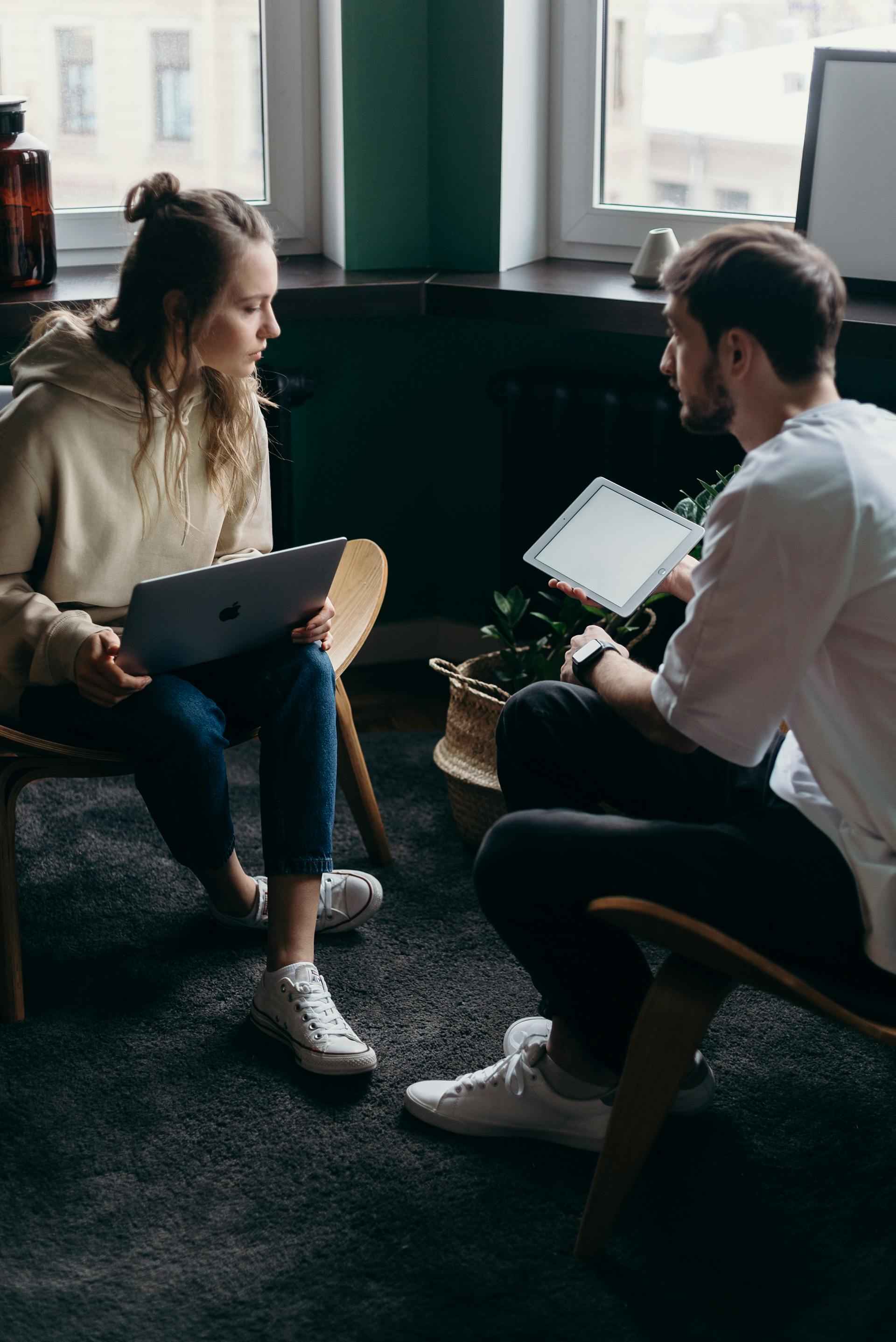 A couple talking while using a laptop and an iPad | Source: Pexels