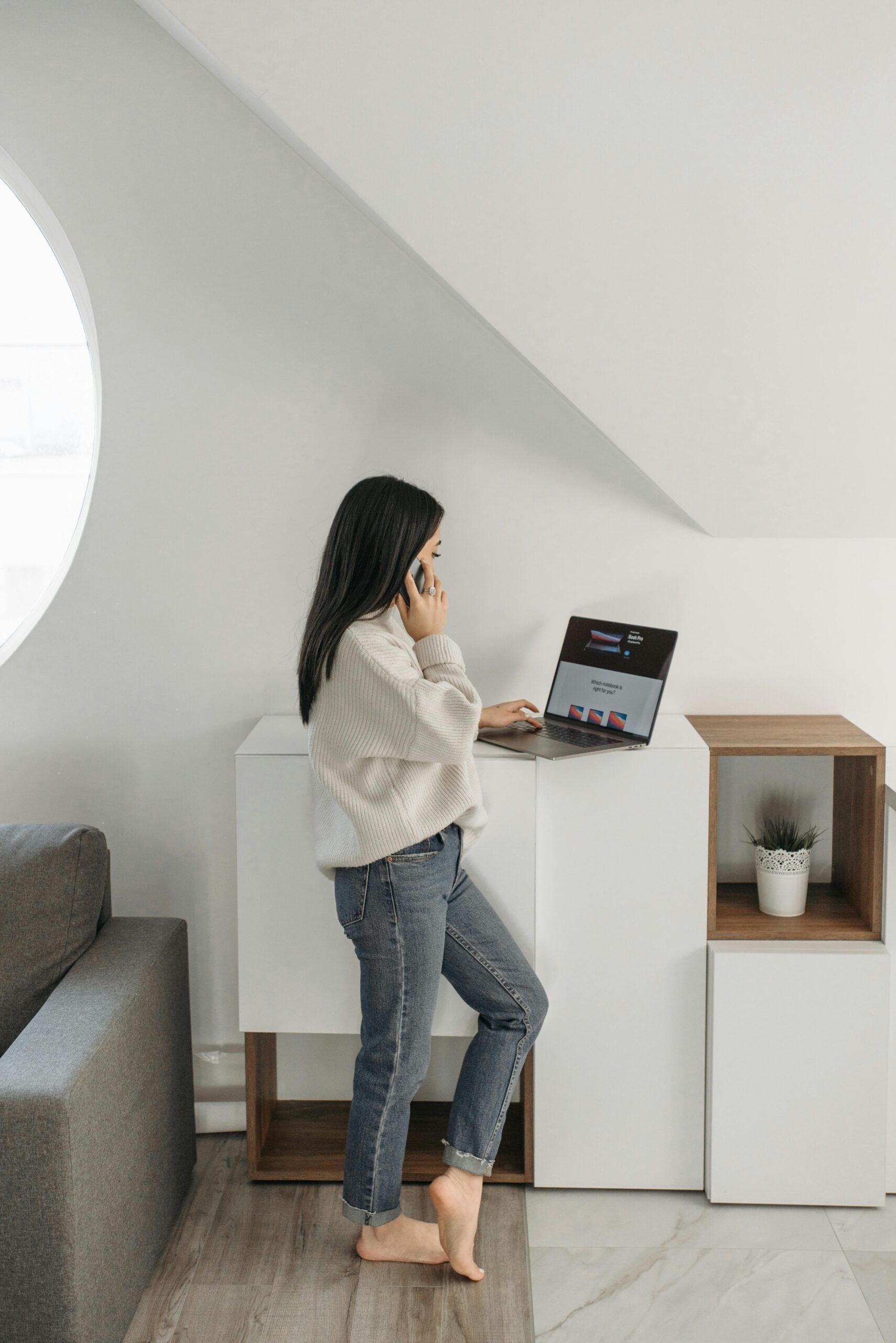 A woman talking on the phone while using a laptop | Source: Pexels