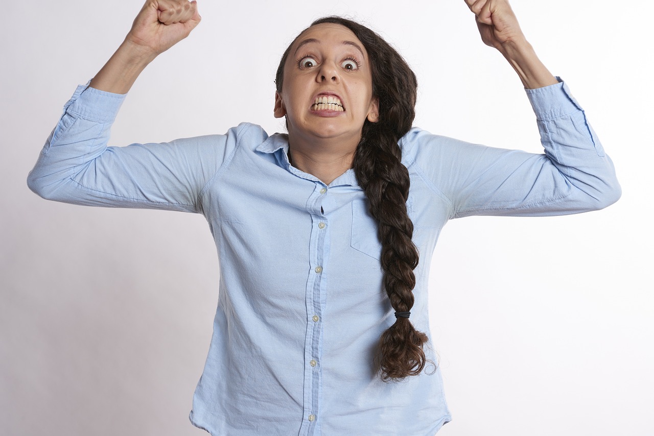 An angry woman baring her teeth and shaking her fists | Source: Pixabay