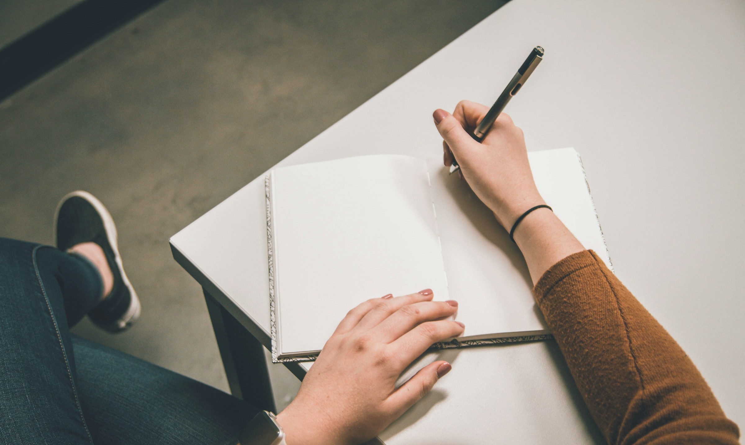 A person writing on a piece of paper | Source: Unsplash