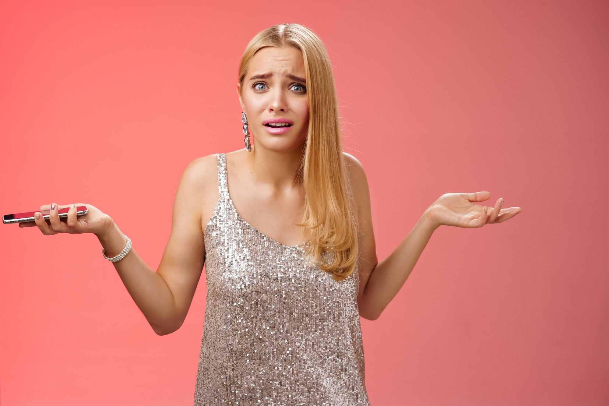 An emotional woman holding a phone while trying to explain herself | Source: Freepik