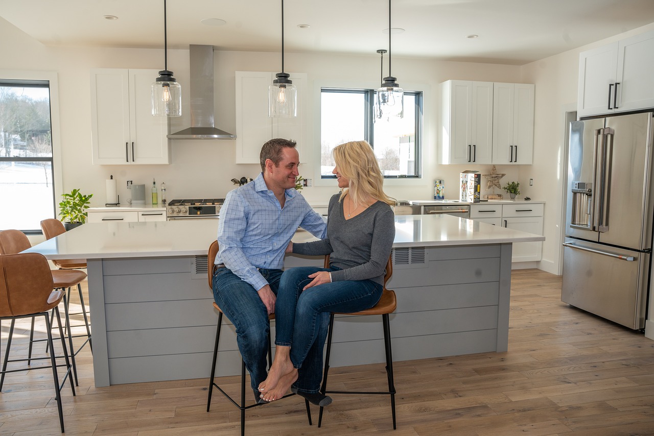 A couple sitting in their kitchen talking | Source: Pixabay