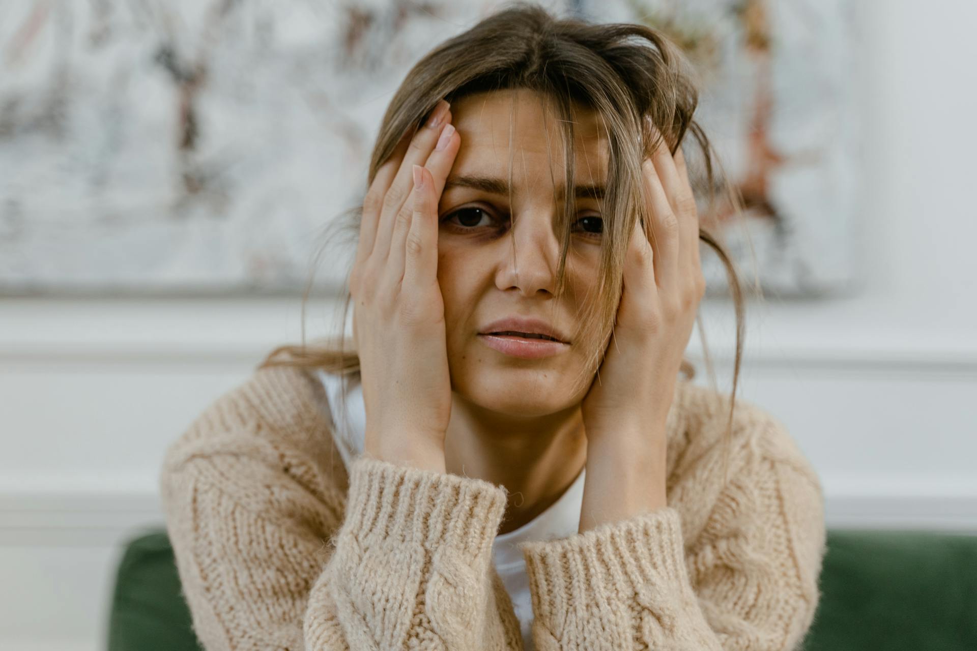 A woman holding her head | Source: Pexels