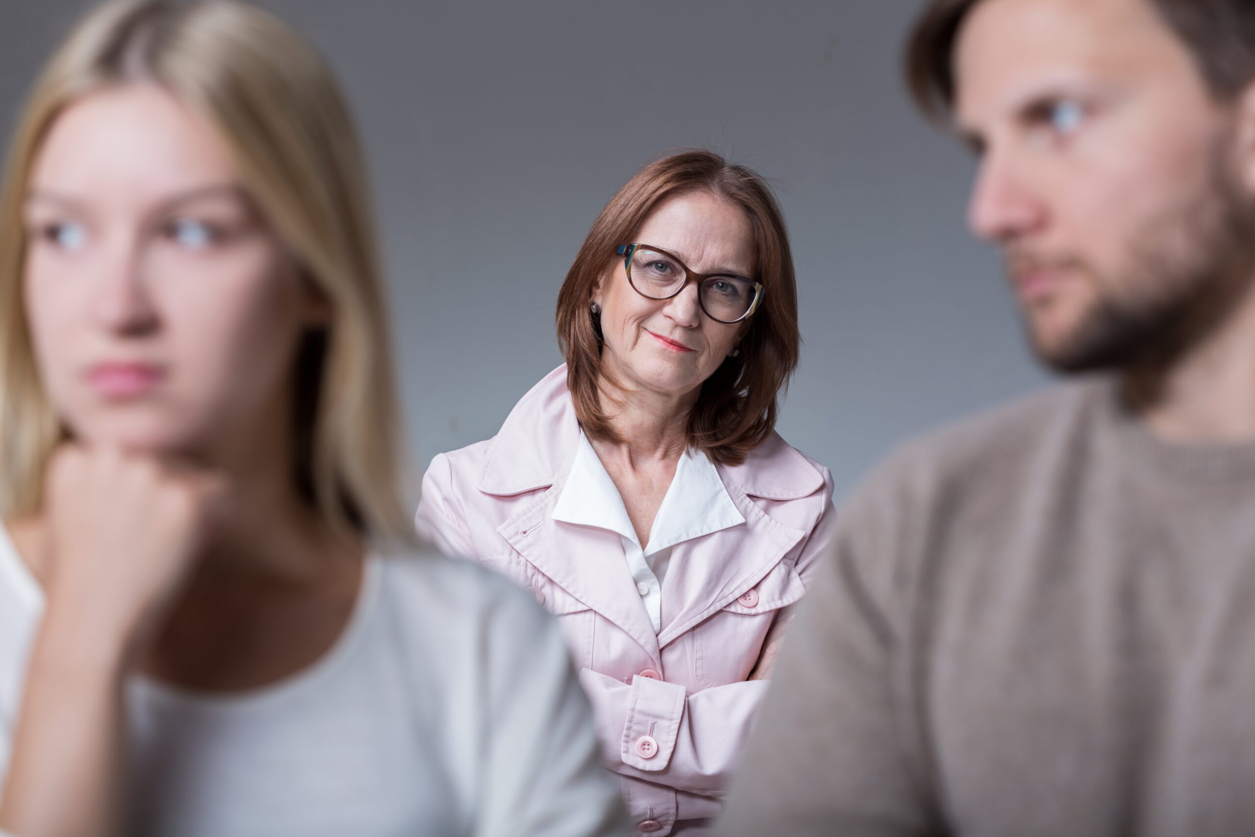An older woman standing behind a couple with a rift | Source: Getty Images