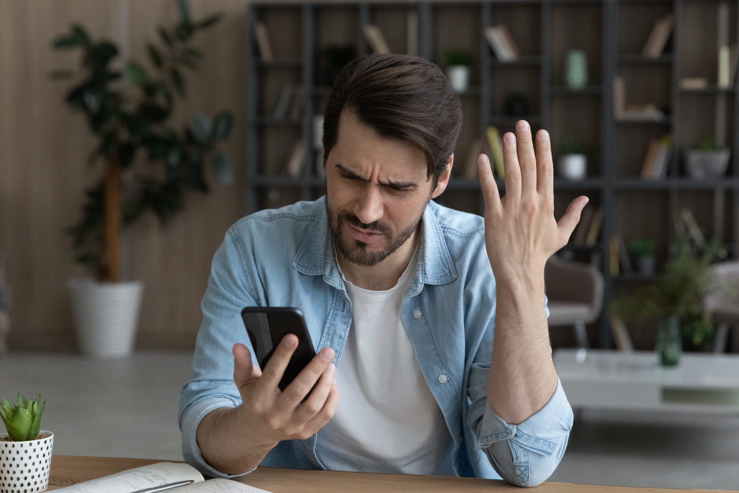 A frustrated and upset man holding a phone | Source: Getty Images