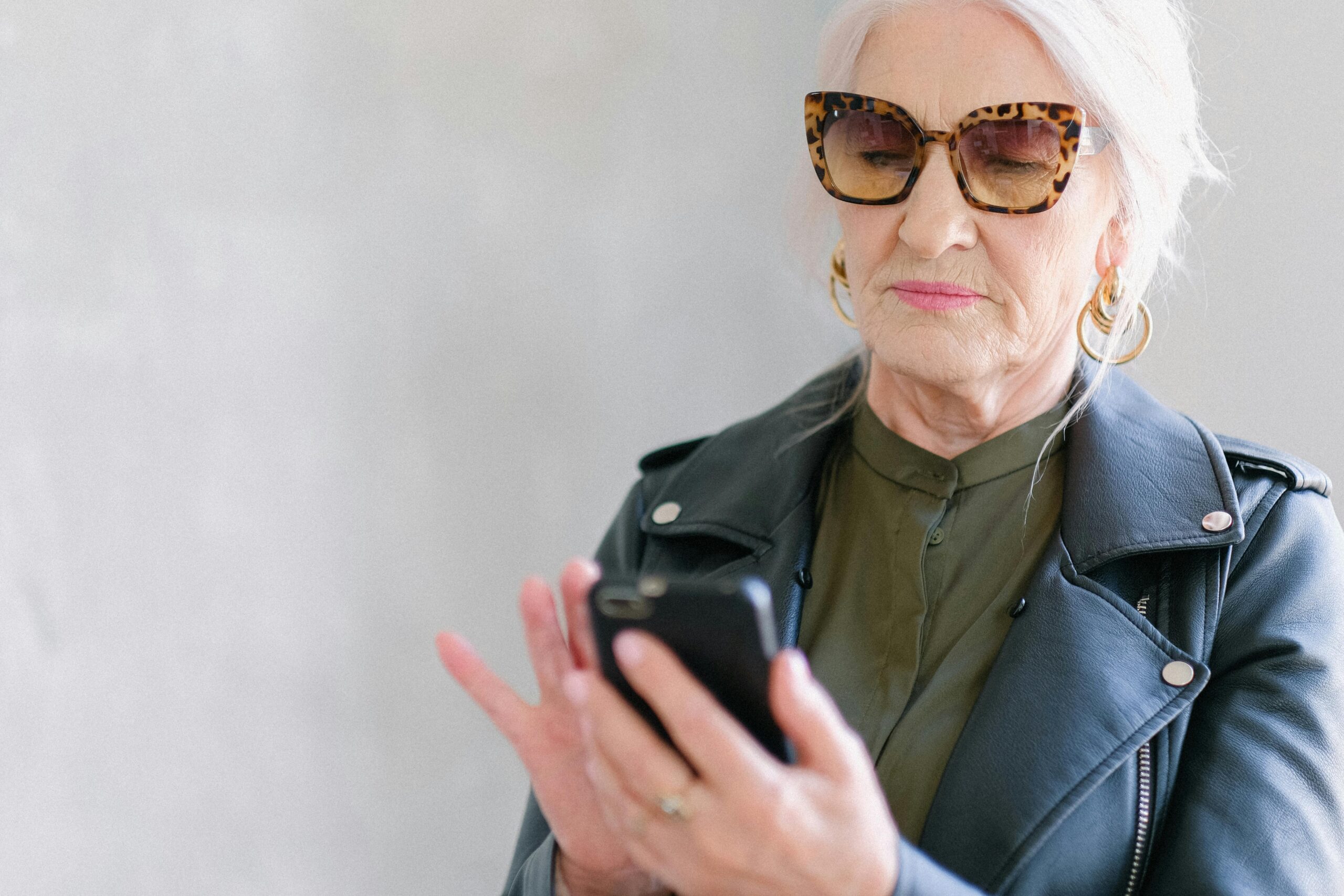 Elderly woman looks at her phone | Source: Pexels