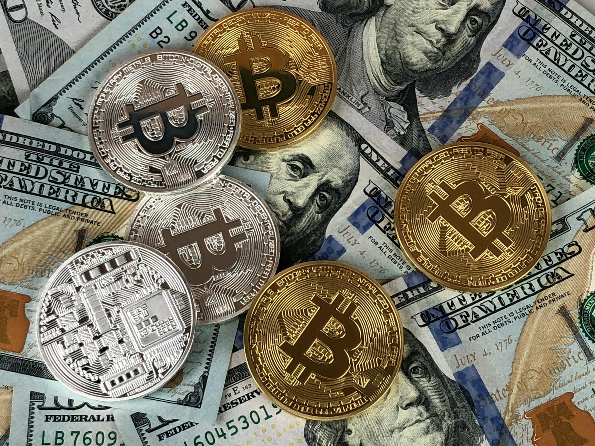 Round silver and gold coins on dollar bills | Source: Pexels