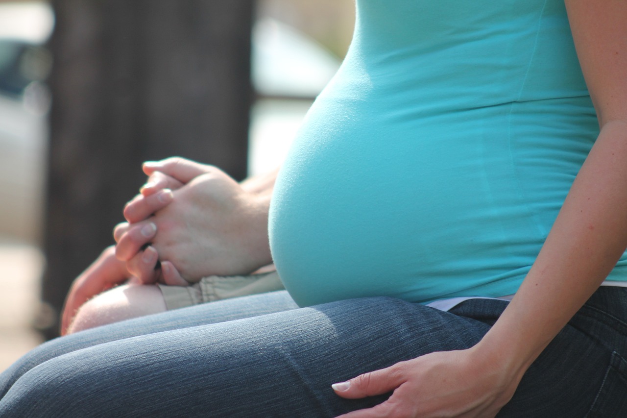 A pregnant woman holding a man
