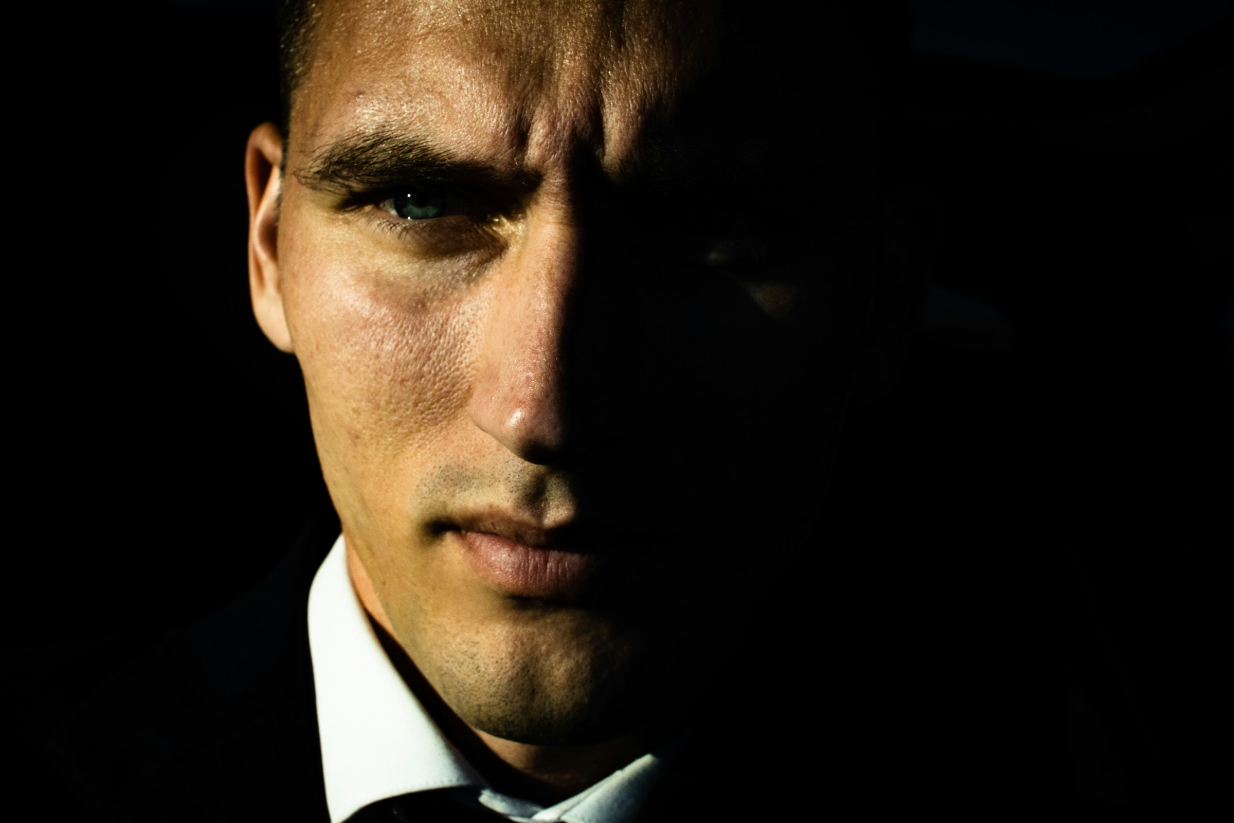 An angry man with partially shadowed face | Source: Pexels